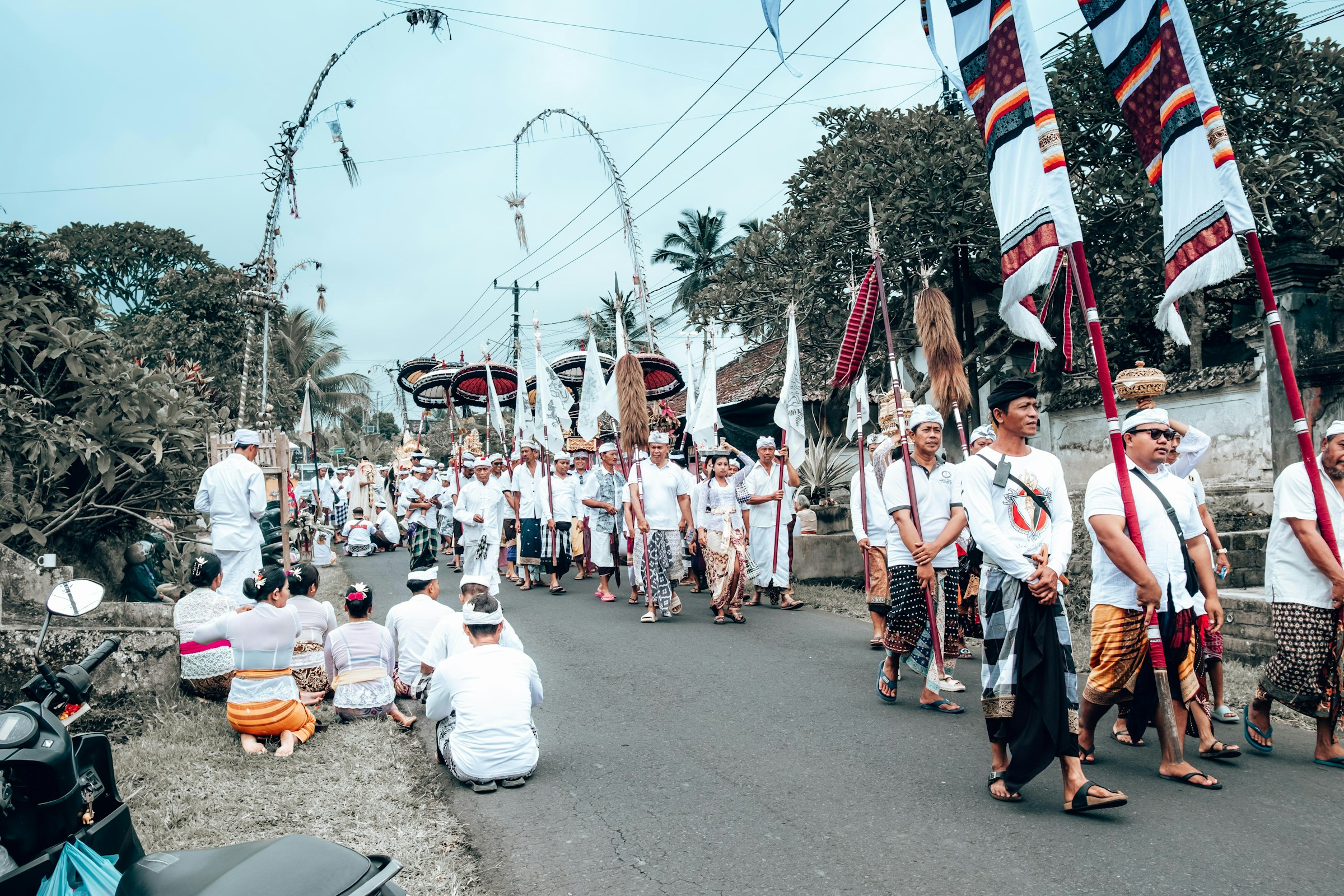 A procession of people in traditional Balinese attire during the Melasti purification ceremony