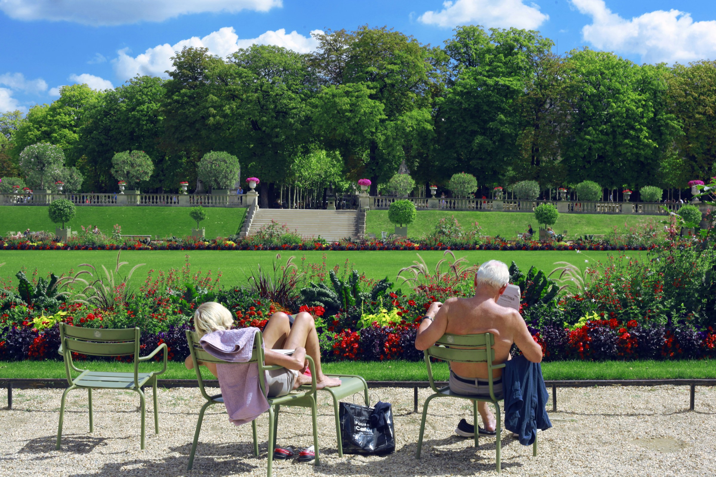 A visitor relaxing on a chair in the Luxembourg Gardens, Paris, during spring