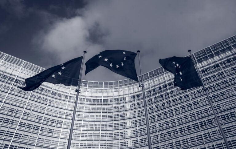 A row of European Union flags on poles outside the Berlaymont building in Brussels