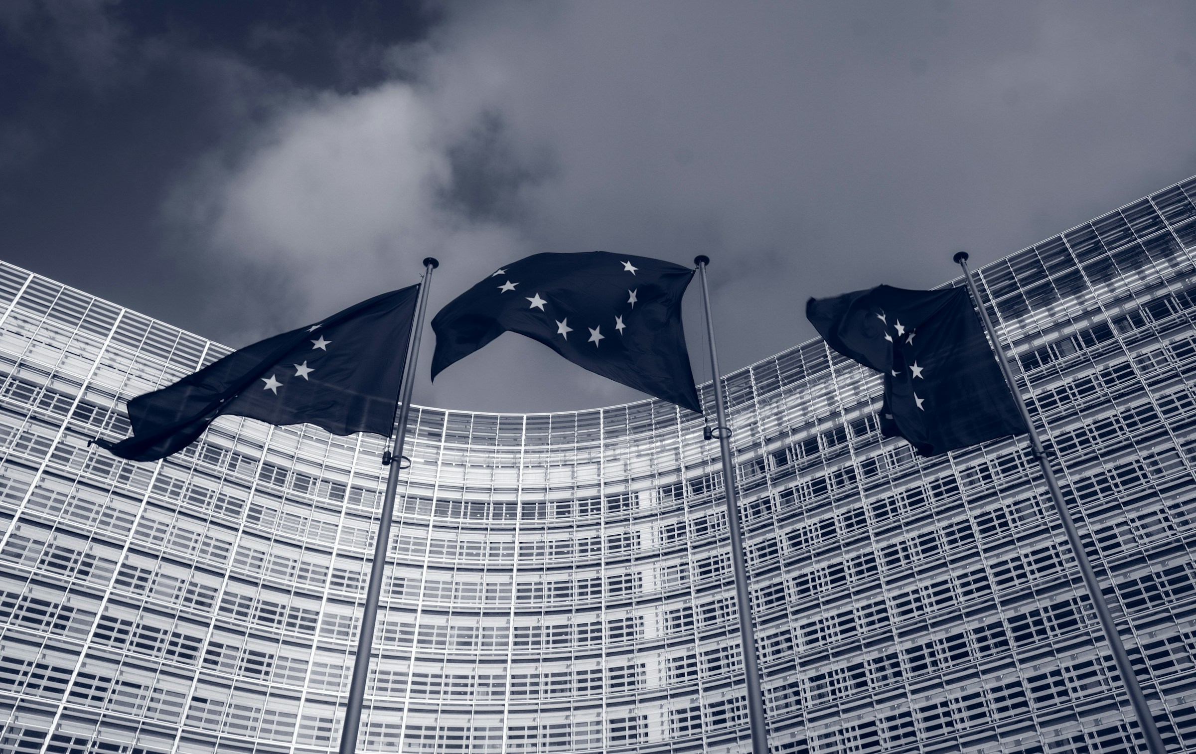 A row of European Union flags on poles outside the Berlaymont building in Brussels