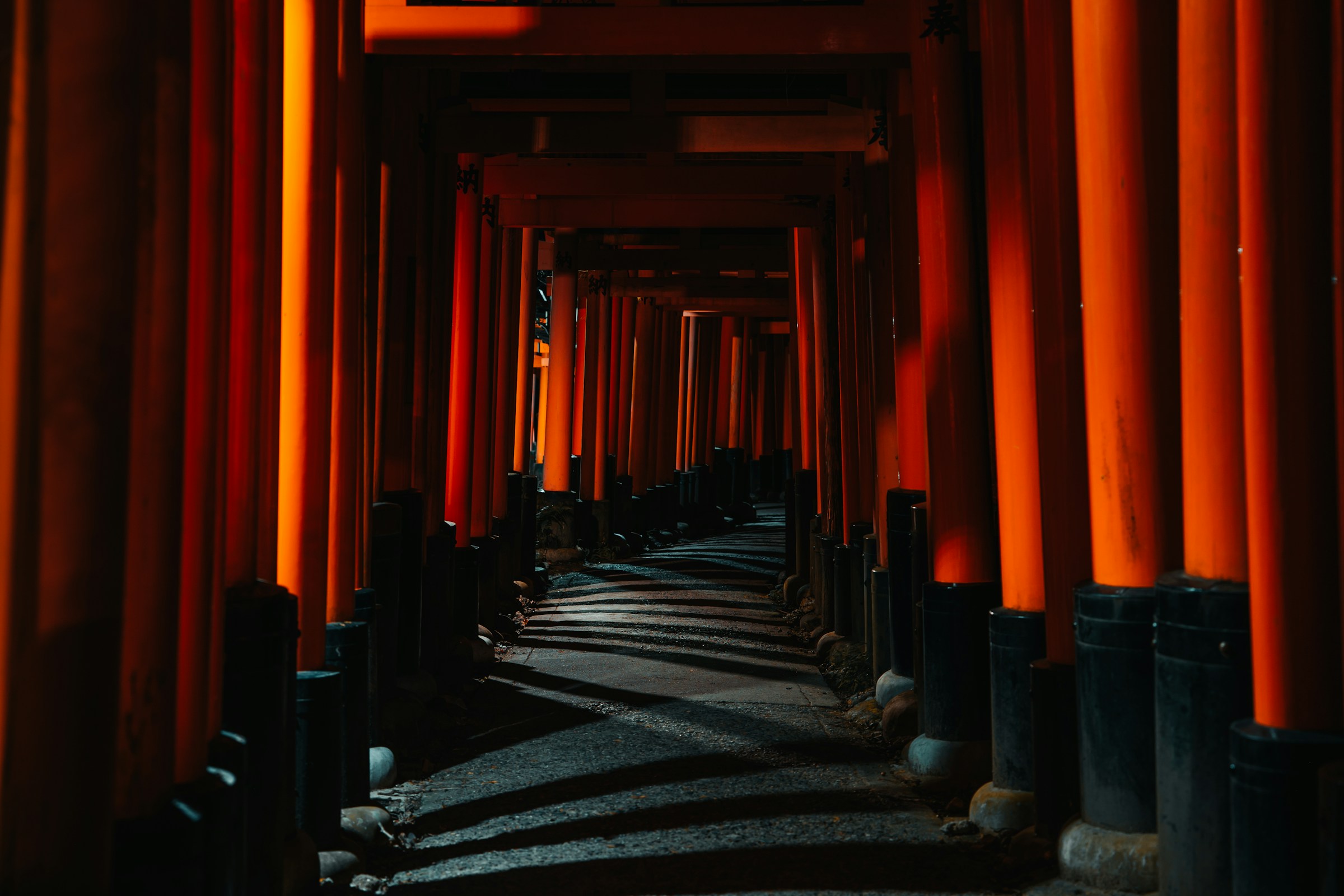 Thousands of vermilion torii gates lining the path up Fushimi Inari shrine in Kyoto at night