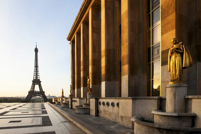 The Eiffel Tower and golden statues at Trocadero, Paris, illuminated by morning sunrise light