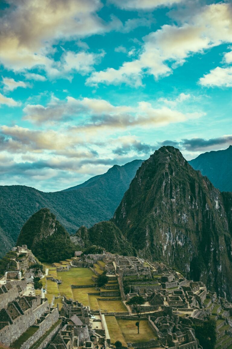 A wide aerial view of the Machu Picchu ruins surrounded by Andes mountains