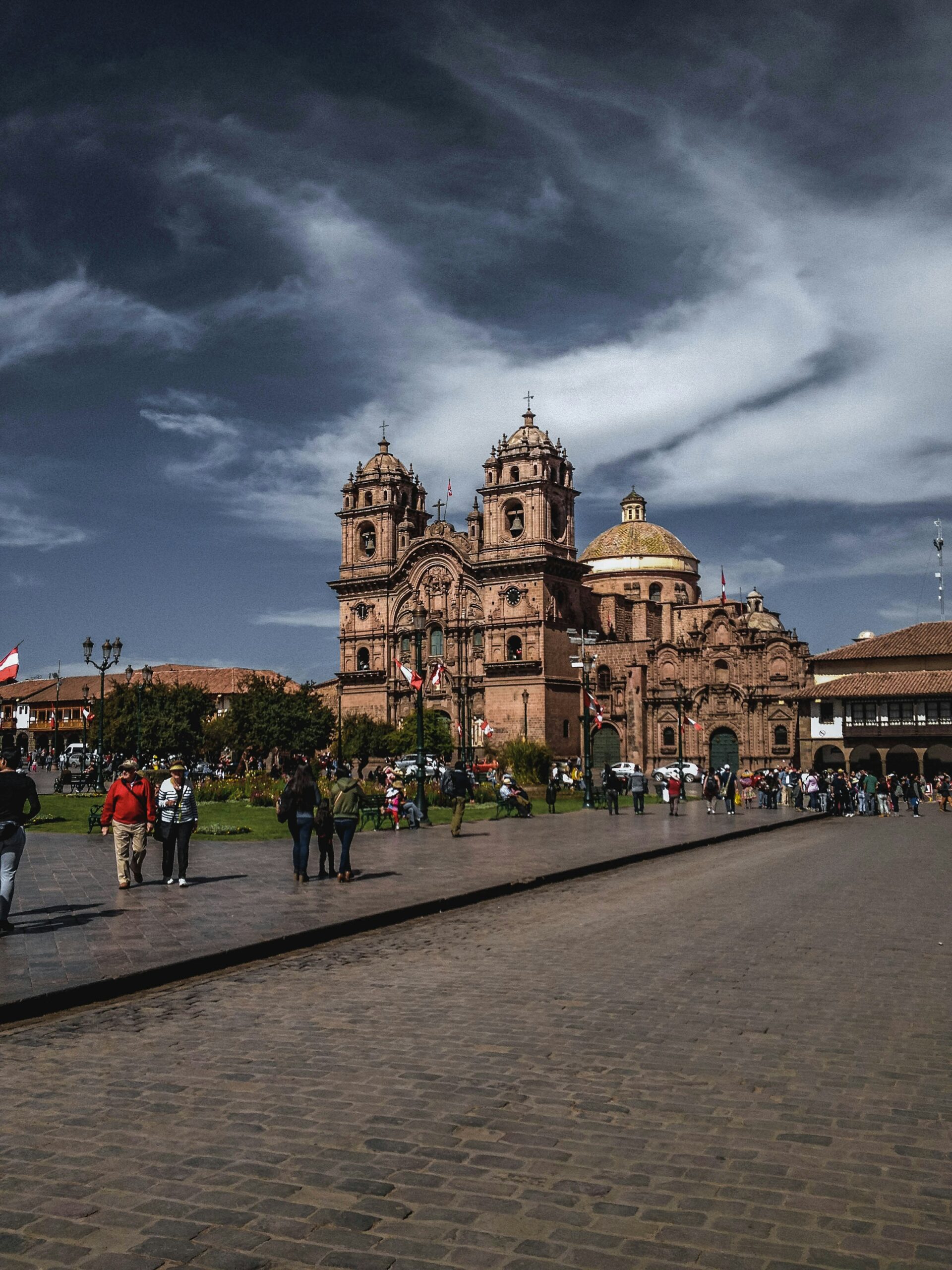 Cusco's colonial cathedral and Plaza de Armas with people walking below the Andes mountains
