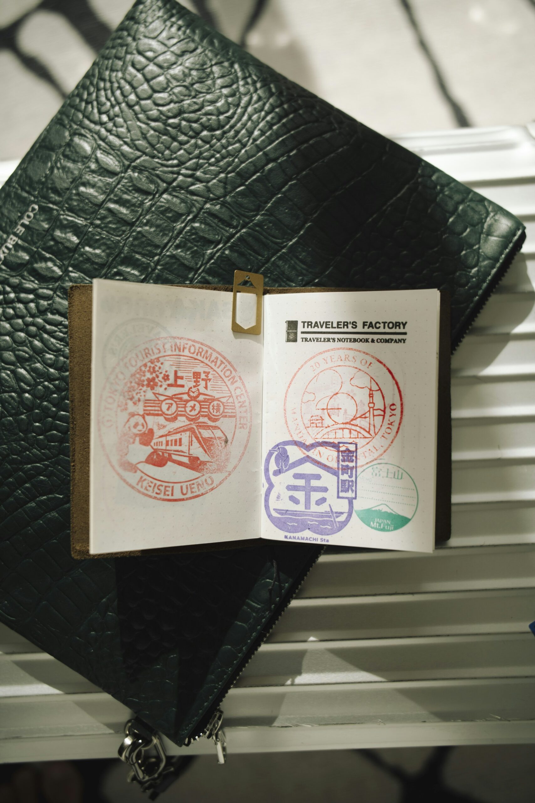 An open passport showing colorful entry and exit stamps alongside travel accessories