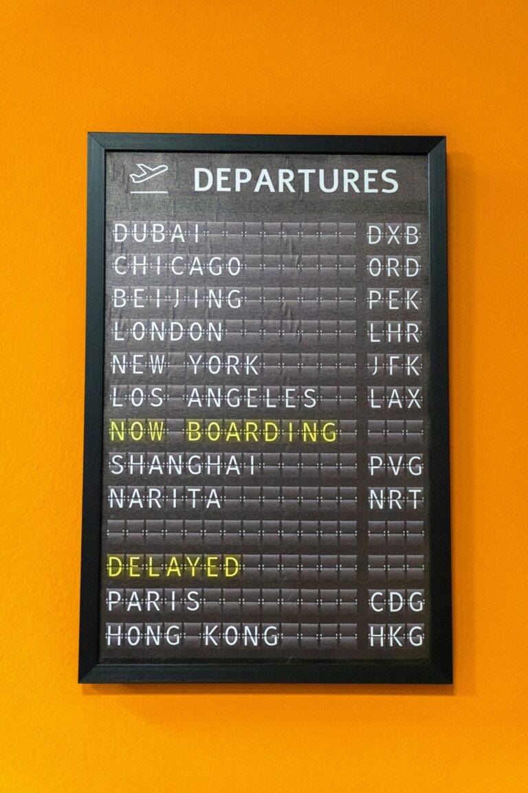 Close-up of an illuminated airport departure board showing flight information
