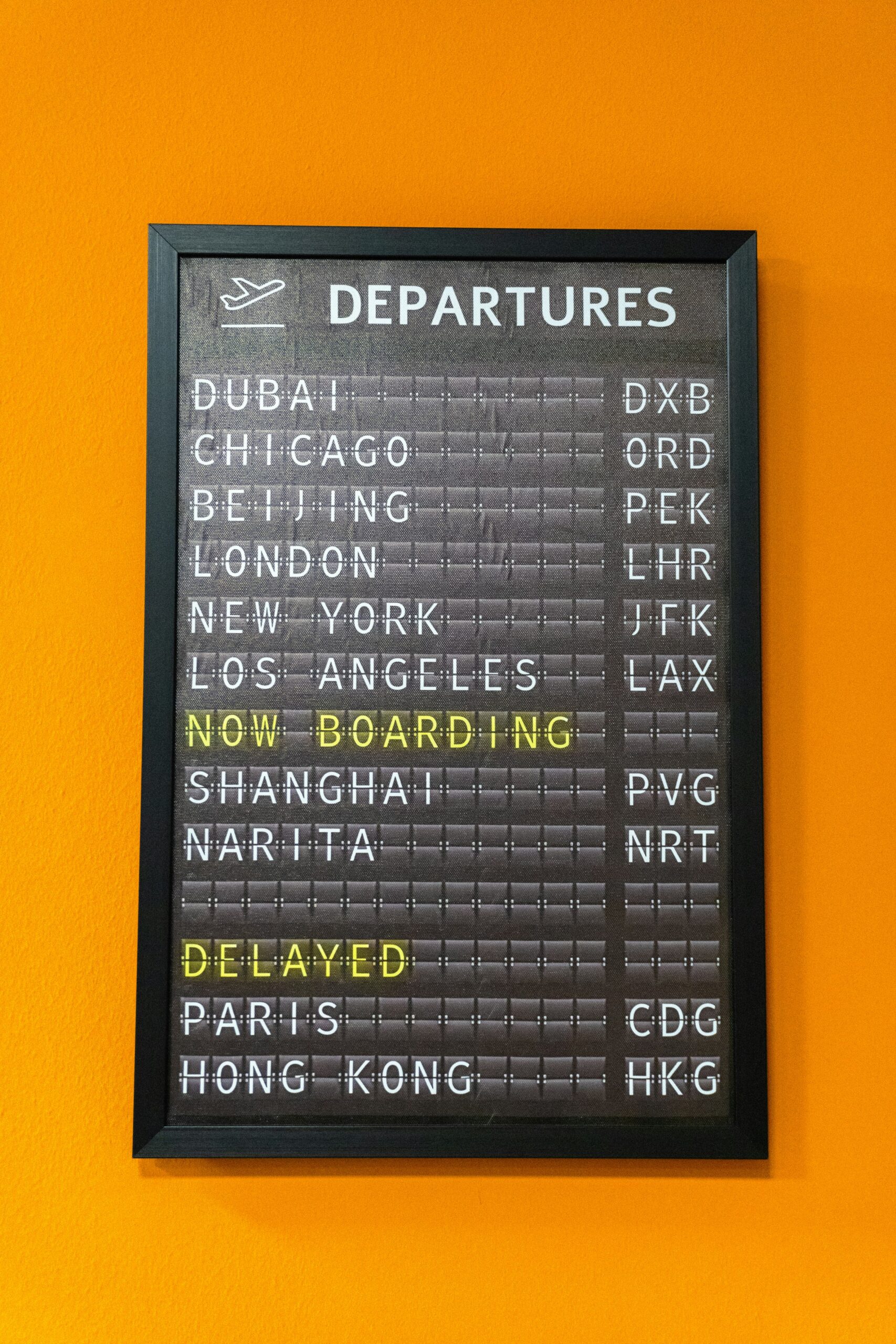 Close-up of an illuminated airport departure board showing flight information
